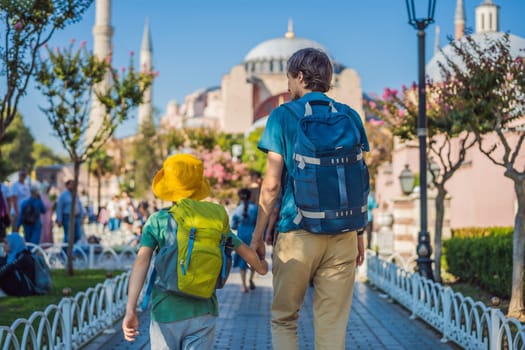 Father and son Tourists enjoy beautiful view on Hagia Sophia Cathedral, famous islamic Landmark mosque, Travel to Istanbul, Turkey. Traveling with kids concept. Sunny day architecture and Hagia Sophia Museum, in Eminonu, istanbul, Turkey. Turkiye.