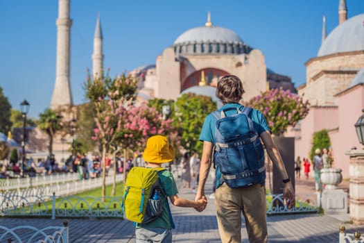 Father and son Tourists enjoy beautiful view on Hagia Sophia Cathedral, famous islamic Landmark mosque, Travel to Istanbul, Turkey. Traveling with kids concept. Sunny day architecture and Hagia Sophia Museum, in Eminonu, istanbul, Turkey. Turkiye.