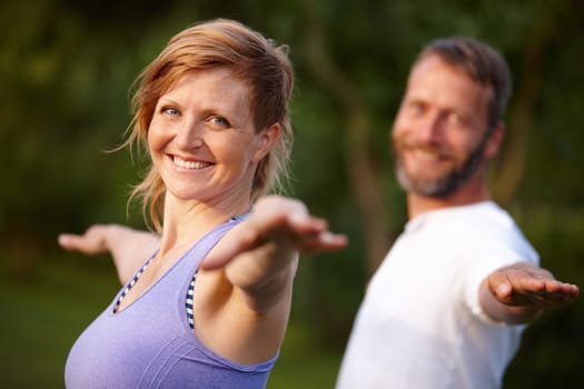 Yoga makes me feel great. Portrait of an attractive woman doing yoga with her partner in the outdoors