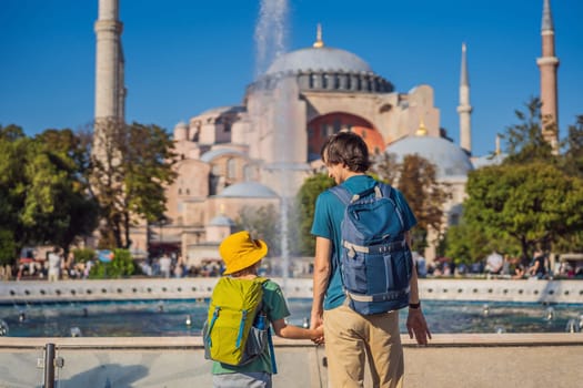 Father and son Tourists enjoy beautiful view on Hagia Sophia Cathedral, famous islamic Landmark mosque, Travel to Istanbul, Turkey. Traveling with kids concept. Sunny day architecture and Hagia Sophia Museum, in Eminonu, istanbul, Turkey. Turkiye.