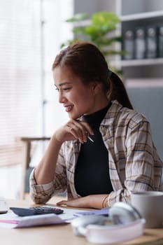 Woman sits on sofa at home, studying and analyze house bills and submitting tax forms..