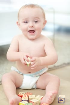 Im so excited and I just cant hide it. Portrait of an adorable little boy wearing his diaper while playing with his blocks