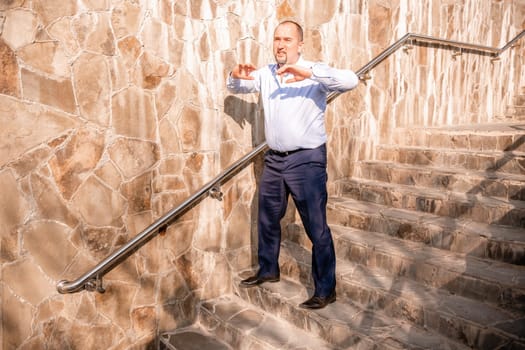 Portrait of a senior professional man in a suit with various problems. A middle-aged businessman with a briefcase descends the stairs.