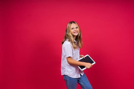 Online school app. Schoolgirl showing tablet computer Empty Screen On red Background. Studio Shot