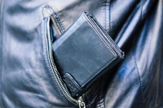 From the pocket of jacket the thief pulls out card banknote money purse wallet.