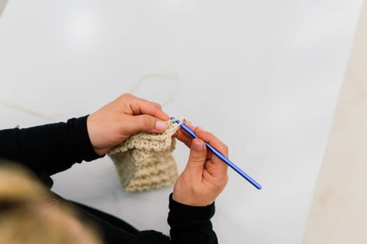 Process of a knitting isolated on white, female hands