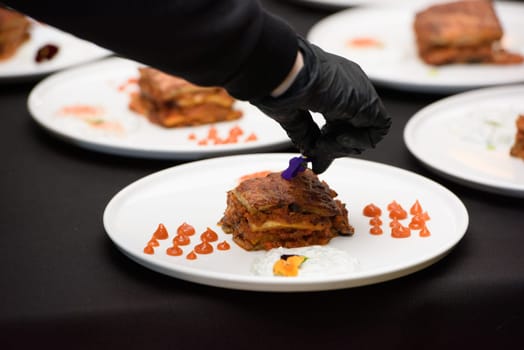 the chef in the restaurant preparing moussaka, baked with beef and cheese