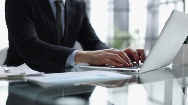 Close-up of male hands typing laptop keyboard. man using laptop