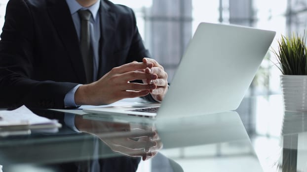 Close-up of male hands typing laptop keyboard. man using laptop