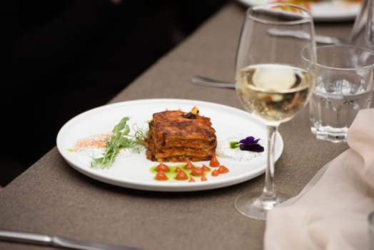 the chef in the restaurant preparing moussaka, baked with beef and cheese