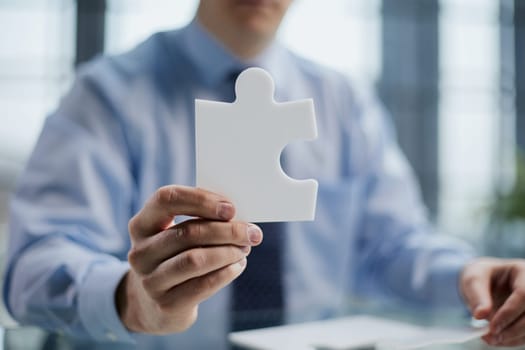 businessman holding a puzzle piece in his hand