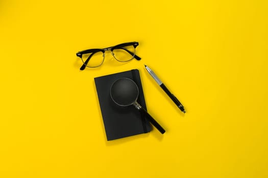 Black objects from the office on a yellow background. Work and creativity. Social media concept hero header image. Top view. Still life. Copy space