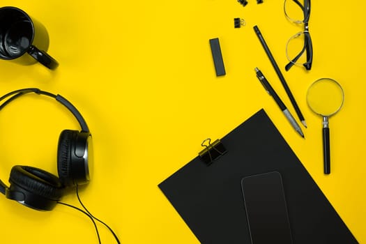 Black objects from the office on a yellow background. Work and creativity. Social media concept hero header image. Top view. Still life. Copy space