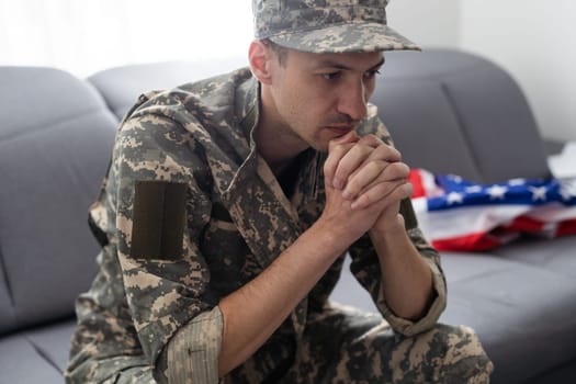 soldier in uniform and cap holding american flag.