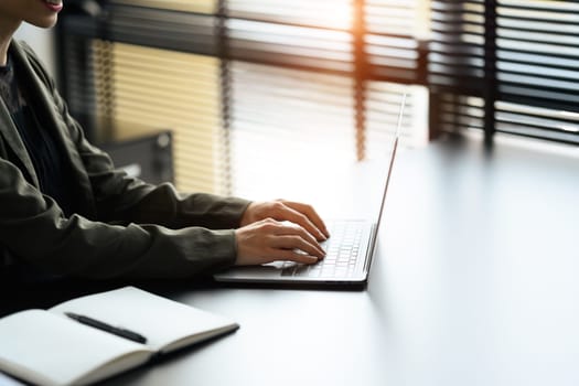 Young economist woman typing business email, analyzing financial market on laptop computer.