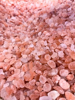 Background of pink Himalayan salt close up. natural light. For puzzles, postcards, spa salons or banners.