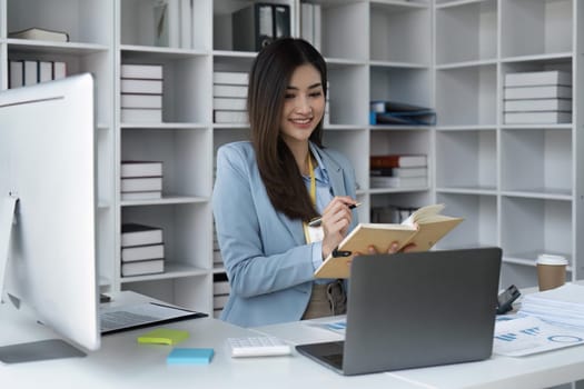 Happy businesswoman analyzing weekly schedule in her notebook.