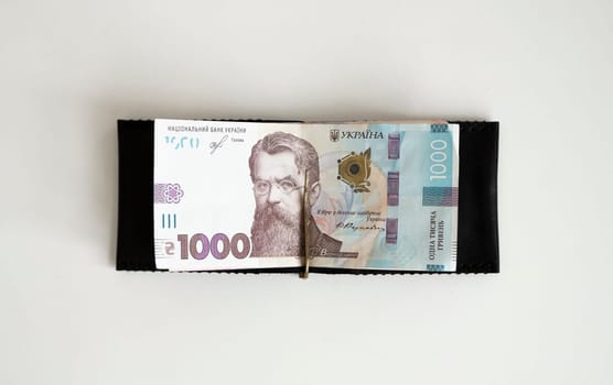 Ukrainian hryvnia money in leather money clip, wallet. Ukraine money on white background with. Currency of Ukraine. Accessories. Money, financess, economy, saving