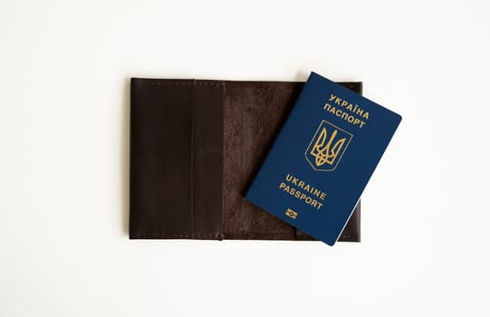 Ukrainian biometric passport id on a leather passport cover to travel the Europe without visas on the table. Inscription in Ukrainian Ukraine Passport