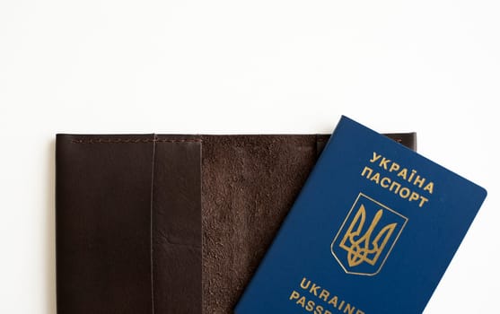 Ukrainian biometric passport id on a leather passport cover to travel the Europe without visas on the table. Inscription in Ukrainian Ukraine Passport