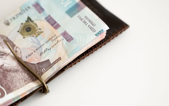 Ukrainian hryvnia money in leather money clip, wallet. Ukraine money on white background with. Currency of Ukraine. Accessories. Money, financess, economy, saving