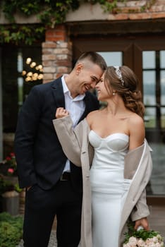 portrait of a young couple of bride and groom on their wedding day in a country cottage