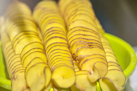 The process of making potato chips at home. Potato finely chopped into thin slices for further frying in sunflower oil. Organic potato chips