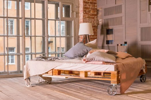 loft apartment interior.Minimalist interior with simple wooden bed, lamp, white bedding.
