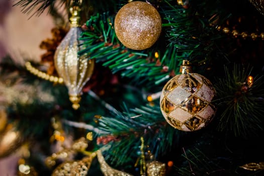 Fir branch with balls and festive lights on the Christmas background with sparkles.