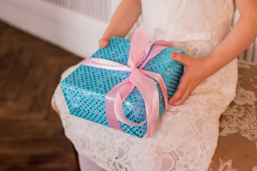 Female hands holding gift box. Copy space. Christmas, hew year, birthday concept. Festive background with bokeh and sunlight. Magic fairy tale