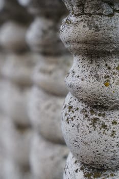 Background texture of an old gray concrete fence with patterned posts.