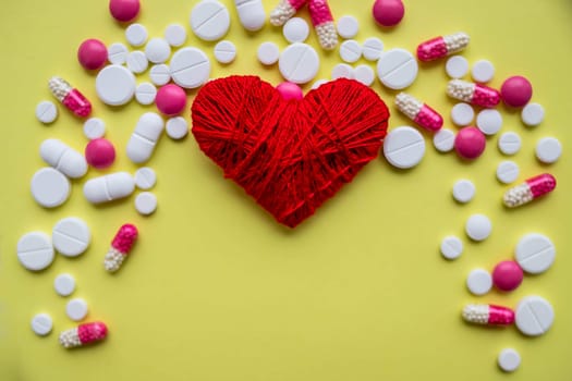 red heart with different pills over white background, healthy life concept.heart disease, heart condition.