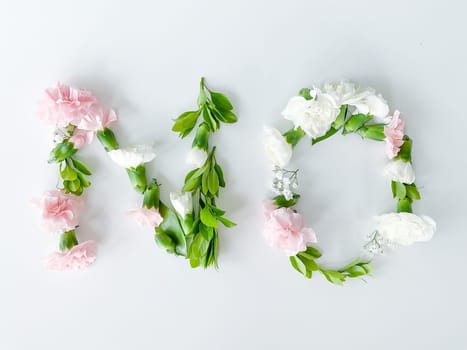 The word NO from flowers on a white background. Spring concept. flat lay