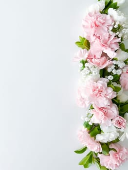 Close up photo of a bouquet of pink and white carnations isolated on a white background. With empty space for text or inscription. For postcard, advertisement or website.