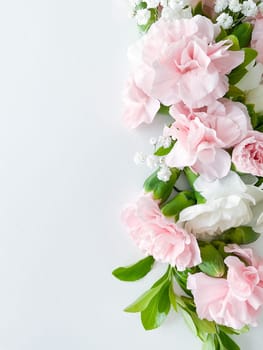 Close up photo of a bouquet of pink and white carnations isolated on a white background. With empty space for text or inscription. For postcard, advertisement or website.