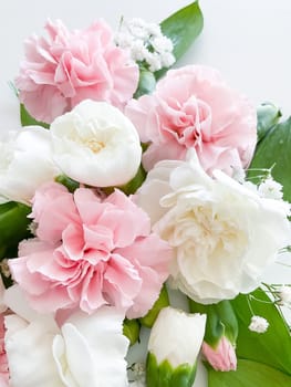 the colorful Flowers -Background with the Flowers. Pink and white carnations, gypsophila and leaves on a white background. Bouquet of flowers.