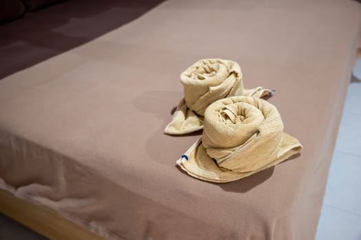 Yellow towel on bed decoration in bedroom interior, Freshly laundered fluffy towels, Towel in hotel room, Beautifully folded toiletries