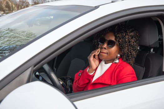 Pretty african american woman in a car doing makeup while standing in a traffic jam, concept a modern married business woman with children saves time, High quality photo