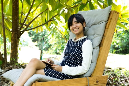 Beautiful young asian woman smiling and happy in garden, attractive female learner studying at garden