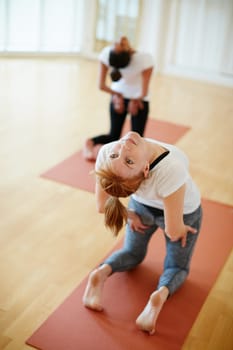 Its their time to unwind...two women doing yoga together in a studio