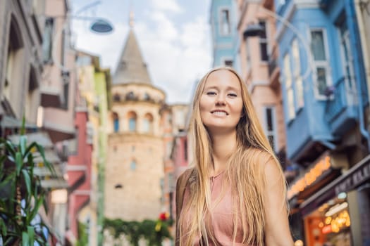Portrait of beautiful woman tourist with view of Galata tower in Beyoglu, Istanbul, Turkey. Turkiye.