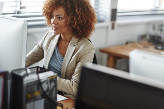 Working hard on her latest project. a beautiful young businesswoman sitting in her office