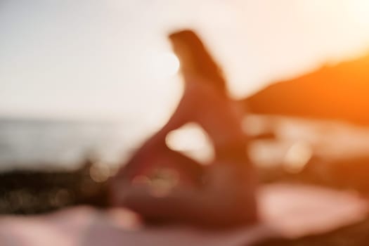 Young woman with black hair, fitness instructor in pink sports leggings and tops, doing pilates on yoga mat with magic pilates ring by the sea on the beach. Female fitness daily yoga concept