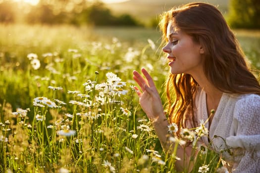 portrait of a beautiful, happy woman in a chamomile field, smelling flowers and enjoying nature. High quality photo