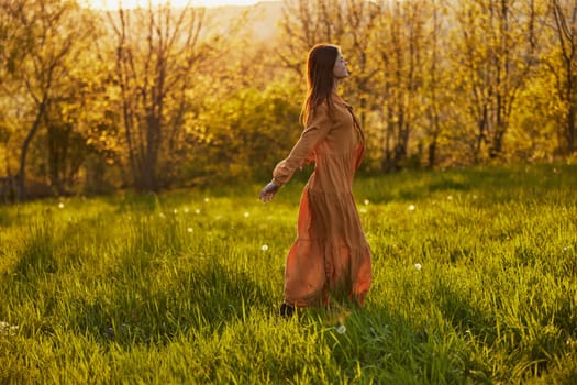 a joyful woman runs through a green field during the sunset enjoying a warm summer day and nature. Horizontal photography in nature. High quality photo