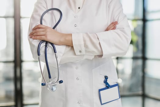 Confident female doctor posing in her office and smiling at camera