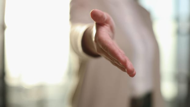 Faceless woman in a business suit holds out her hand for a handshake while. Female boss makes a successful deal.