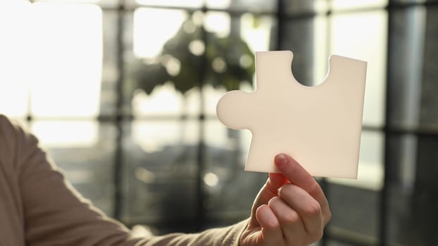 Business Woman holding two blank white puzzle pieces in his hands conceptual of solving a problem