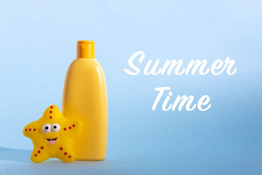 Yellow plastic bottle with baby cosmetic and funny toy. Sunscreen lotion. The concept of children's sun protection. Text Summer time