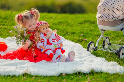 girl sitting with her doll on a blanket